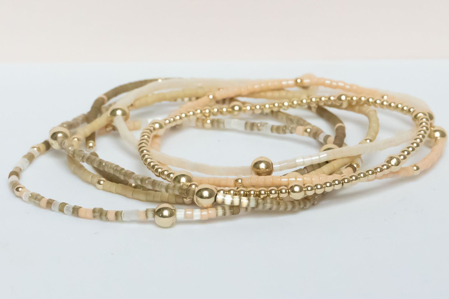 Set of seven bracelets from the hope bead co natural glam collection. Featuring Japanese glass and 14-karat gold-filled beads on stretch bracelets.